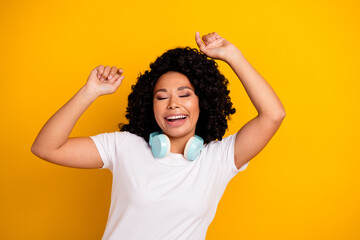 Photo of funky excited lady dressed white t-shirt dancing enjoying music headphones isolated yellow...