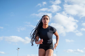 Female athlete during sprint - obrazy, fototapety, plakaty