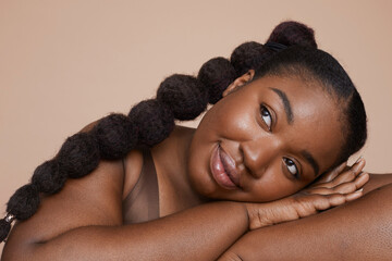 Studio shot of smiling young woman with braided hair