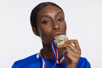 Studio portrait of athletic woman with golden medal © Cultura Creative