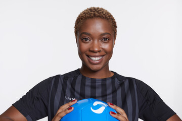 Studio portrait of smiling female soccer player with ball © Cultura Creative