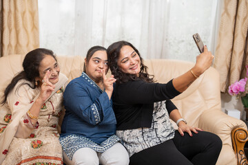 Family portrait with down syndrome woman taking selfie at home