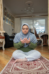 Muslim woman with down syndrome praying at home