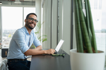 Naklejka na ściany i meble Businessman with laptop working in modern office
