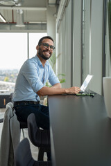 Naklejka na ściany i meble Businessman with laptop working in modern office
