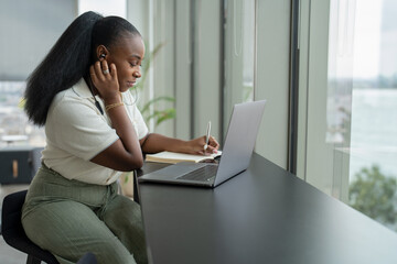 Businesswoman with laptop working in modern office