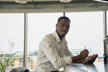 Portrait of young businessman using digital tablet in office