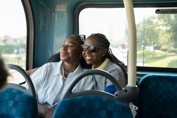 Young female friends riding city bus - obrazy, fototapety, plakaty