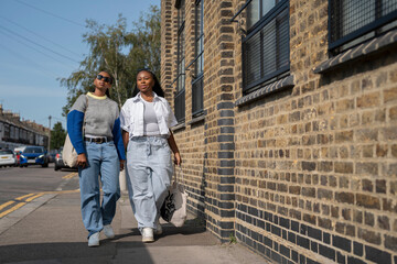 Young female couple holding hands in street