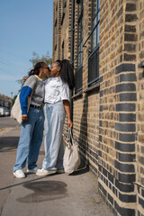 Young female couple kissing in street