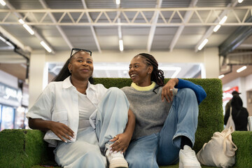 Young women relaxing on sofa in shopping center
