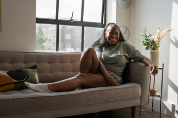 Obraz premium Portrait of young woman resting on sofa at home