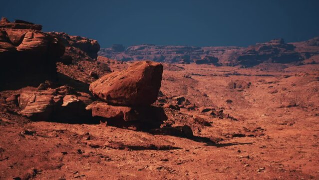 A strikingly colossal rock emerges as a solitary masterpiece against the backdrop of the vast, arid desert.
