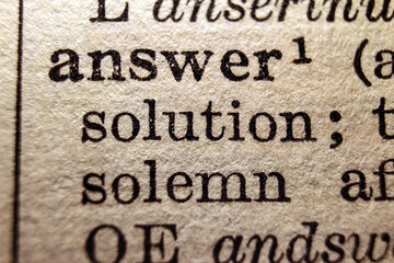 Words "answer" and "solution" printed on book page, macro close-up