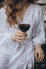 young woman in a white shirt with a glass of wine in her hands