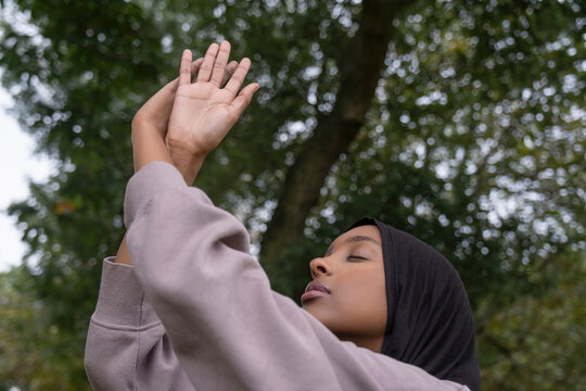 Portrait of woman in hijab practicing yoga in park