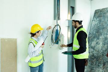 team electrical engineers or technicians is professionally inspecting the wiring and systems in the building. Check electrical equipment to meet safety standards. Use a tablet to check buildings.
