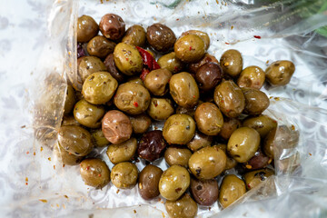Ripe spicy marinated olives in a plastic bag