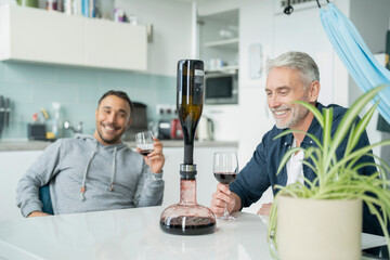 Male couple using wine breather decanter at home