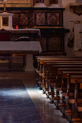 Celano, Italy The interior of the  Chiesa Sant'Angelo church with pews in the sunlight.