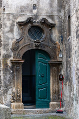 Fototapeta na wymiar Scanno, ItalyA green door and a red broom in a narrow alley.