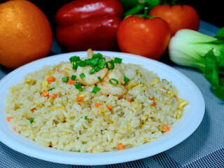 Chinese Shrimp Fried Rice with white plate red tomato 