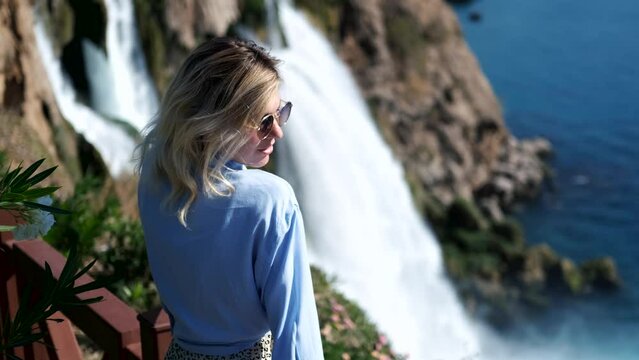 charming woman portrait against the backdrop of a waterfall