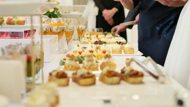 Catering service on banquet table with canape snacks in restaurant or hotel. Decorated food set on birthday, wedding celebration or business conference event venue. Selective focus.