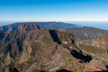 Scenic view of mountain ridges and majestic canyon of rugged terrain on Madeira island, Portugal, Europe. Idyllic hiking trail to mountain peak Pico Ruivo. Coastal landscape on sunny day. Tranquility