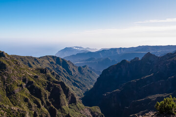Scenic view of misty hills and cloud covered coastline of majestic Atlantic Ocean on Madeira island, Portugal, Europe. Idyllic hiking trail to mountain peak Pico Ruivo. Coastal landscape on sunny day