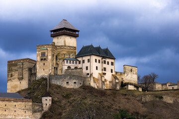 Obraz premium Trenčín castle during the winter without snow, with a cloudy sky with dark clouds.