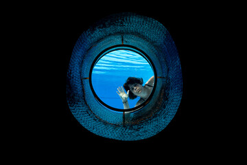 Woman Swimming and Greeting in the Ship Porthole in Underwater in Swimming Pool in a Sunny Day in...