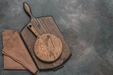A stack of two cutting boards and a linen napkin on a dark background. Kitchenware. Top view, flat lay. - 747327153