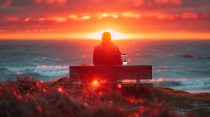 Foto op Plexiglas Solo Man traveler gazes at ocean, sitting at wooden table with laptop, working remotely, a beautiful North landscape on the background © Anna Zhuk
