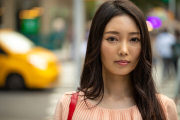 Asian woman serious sad face on city street portrait