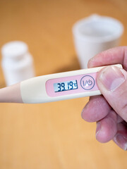 Checking temperature at home with digital thermometer, high body temperature, fever, high-Grade...