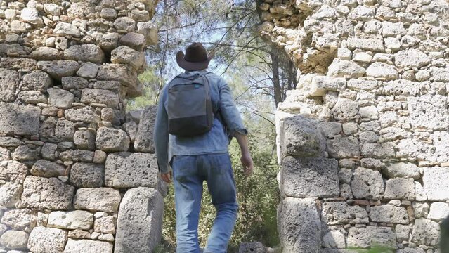 An archaeologist is a tourist in the jungle on the background of ancient ruins
