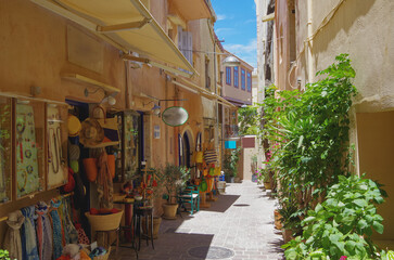 Fototapeta na wymiar Picturesque scenic narrow alleys with traditional cobblestone streets and Souvenir shops in Old Town of Chania City in famous tourist attraction Crete island in Kreta Greece during Summer cruise