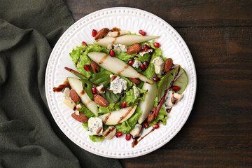 Delicious pear salad with sauce on wooden table, top view