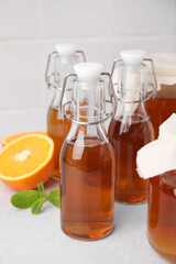 Tasty kombucha, orange and mint on white table