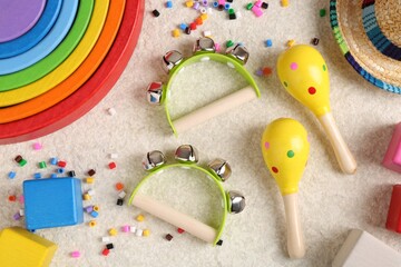 Baby song concept. Kids musical instruments and toys on beige carpet, flat lay