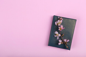Multipurpose composition, branch of cherry blossoms on a present wrapped in blue and gold paper....