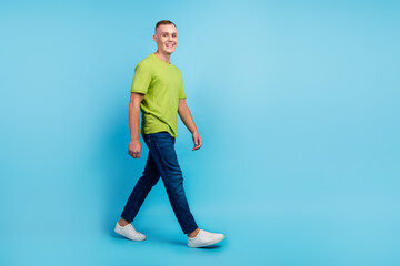 Fototapeta na wymiar Full length body size photo smiling man in casual clothes walking isolated blue color background