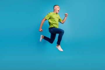 Fototapeta premium Full length profile photo of cheerful man run empty space isolated blue color background