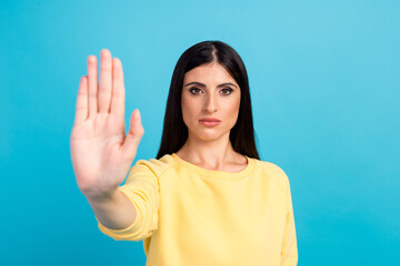 Lady making stop gesture with her palm, on a blue background