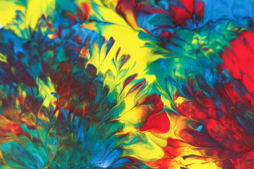 Abstract background of acrylic paint in blue, red and yellow tones.