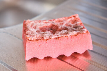 The view of a worn kitchen sponge for washing dishes. Selective focus. Side view