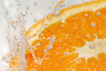 A juicy orange slice with water droplets on a white background