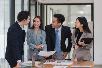 Young motivated Asian business team discussing oh business strategy in the modern meeting room.