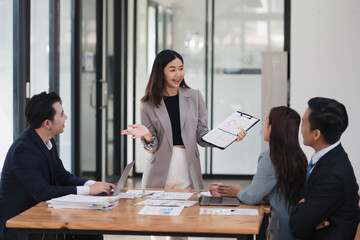 Young beautiful businesswoman presenting her idea or business strategy to the team in the meeting room.